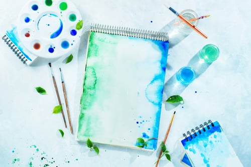 Preview: Drawing spring concept with artist tools, green and blue watercolor sketchbooks, brushes and color