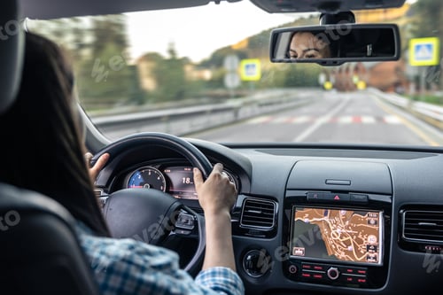 Preview: Woman driving a car, hands on the wheel close-up, view from the back to the road.