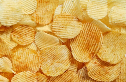 Preview: Slices Golden chips with stripes lying slides background texture. View from above