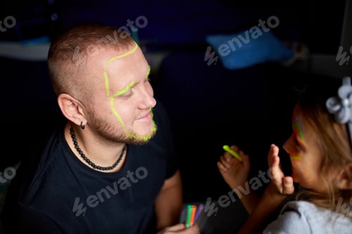 Preview: Daughter and father paint a face, having fun, leisure together at home