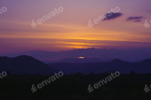 Preview: Sun hiding behind the mountains. Sunset background.