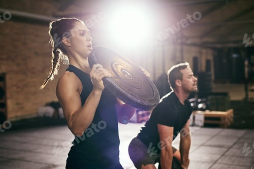Preview: Two sportsmen having workout with weight disks