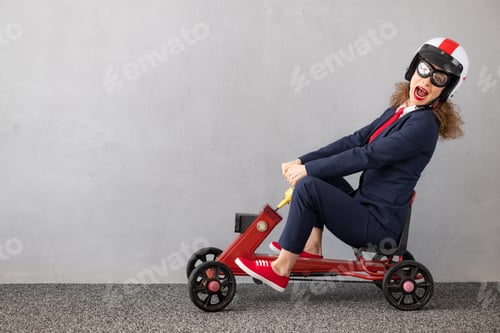 Preview: Successfull businesswoman driving toy car outdoor