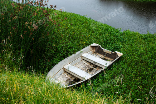 Preview: Old rowboat on grassy riverbank