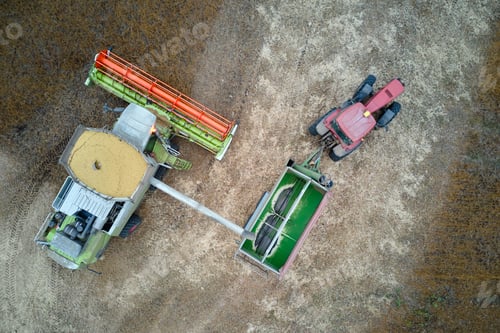 Preview: Aerial view of combine harvester unloading grain in cargo trailer