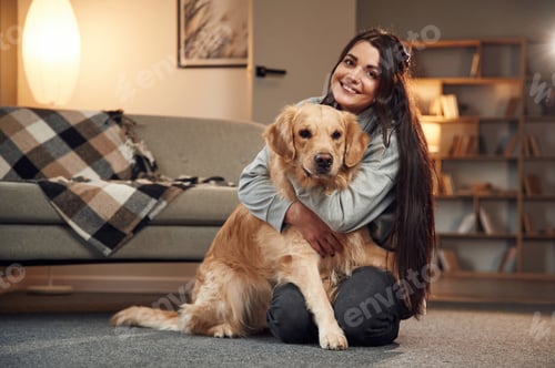 Preview: Sitting and smiling. Woman is with golden retriever dog at home