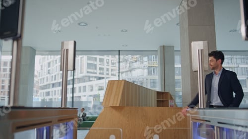 Preview: Confident businessman passing electronic gates with face recognition system.