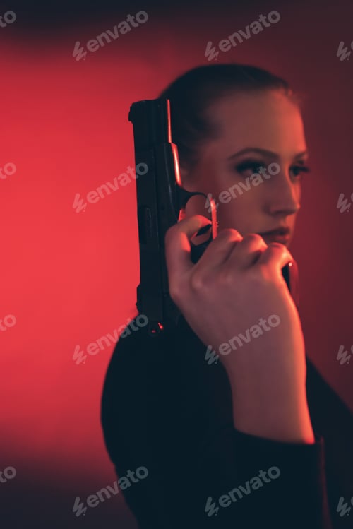 Preview: Blonde Woman With Pistol Against Red Background.