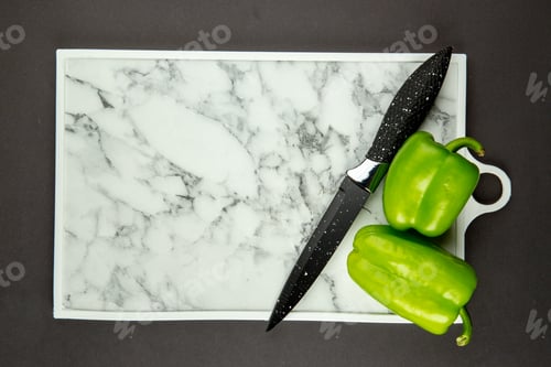 Preview: top view white cutting board with green bell-peppers and knife on dark background photo cut cuisine