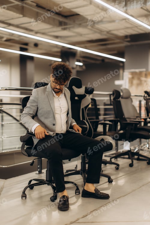 Preview: Man in Office Trying Different Ergonomic Chairs for Comfort and Style
