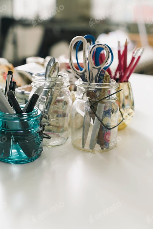 Preview: Jars of scissors, pens and pencils in design studio