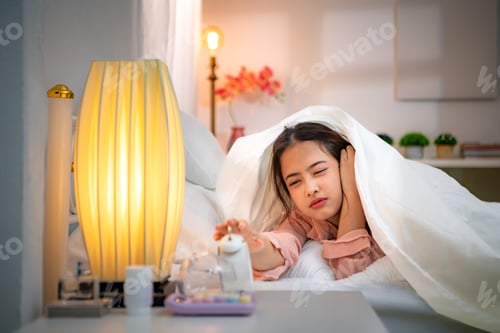 Preview: Asian young woman on the bed in the bedroom trying to wake up and prepare for work