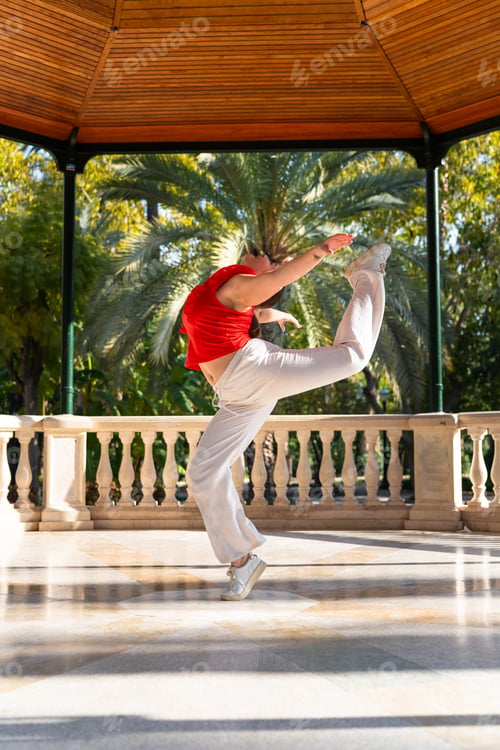 Preview: Young woman performing fitkid acrobatics in a gazebo