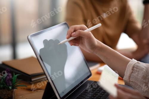 Preview: Professional designers team meeting together on the desk using a tablet.
