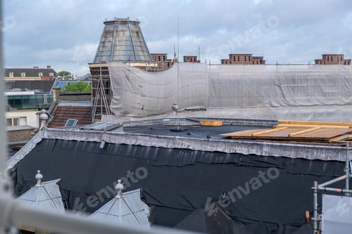 Preview: Roof construction, insulation work. Metal scaffolding, timber and waterproof membrane at rooftop.