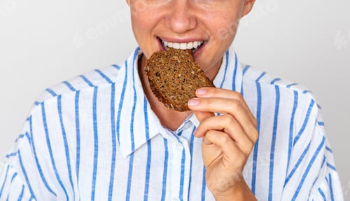 Preview: Close-up female eating dark rye bread with grain