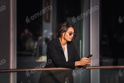 Preview: Woman in Business Suit Using Smartphone Outside
