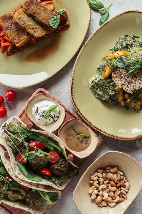 Preview: food composition with arranged vegetarian dishes served on grey surface