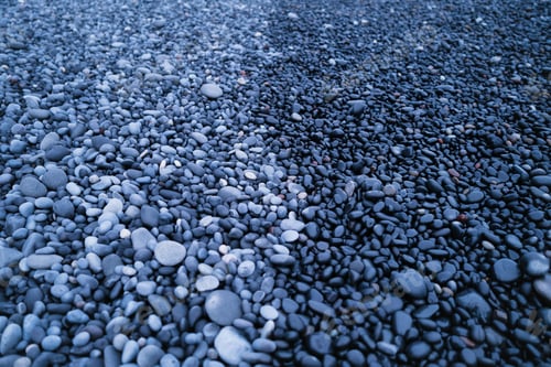 Preview: Gray pebbles as a background. Round stones on the beach.