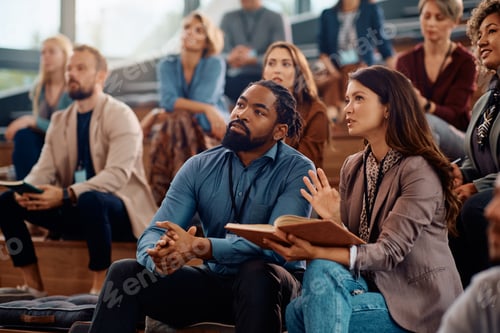 Preview: Business colleagues communicating during a seminar in conference hall.