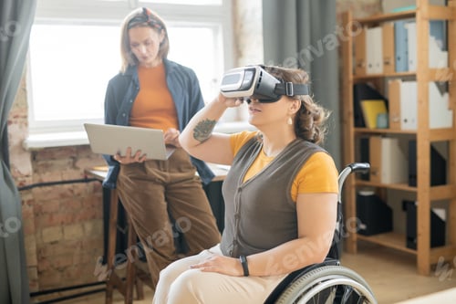 Preview: Disable female in vr headset sitting in wheelchair and watching presentation