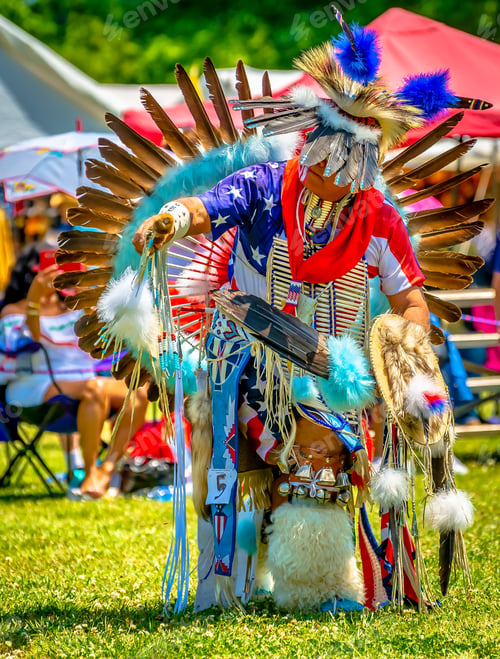 Preview: Vertical closeup shot of a person in a colorful Indian-American festive costume with feathers