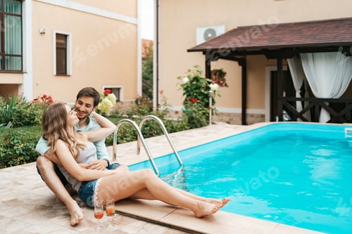 Preview: Romantic Couple Relaxing Together Beside Swimming Pool