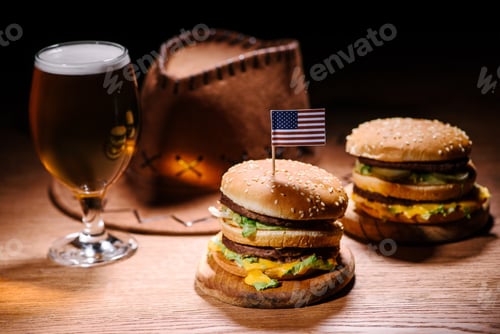 Preview: tasty burgers on wooden table with american cowboy hat and glass cold of beer