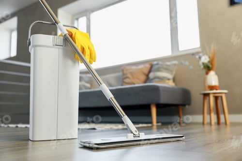Preview: Cleaning supplies: mop, gloves, bucket with wringer on wooden laminate floor