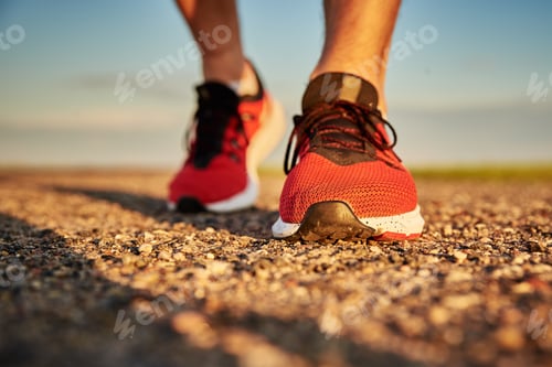 Preview: Runner man feet on road at the sunset