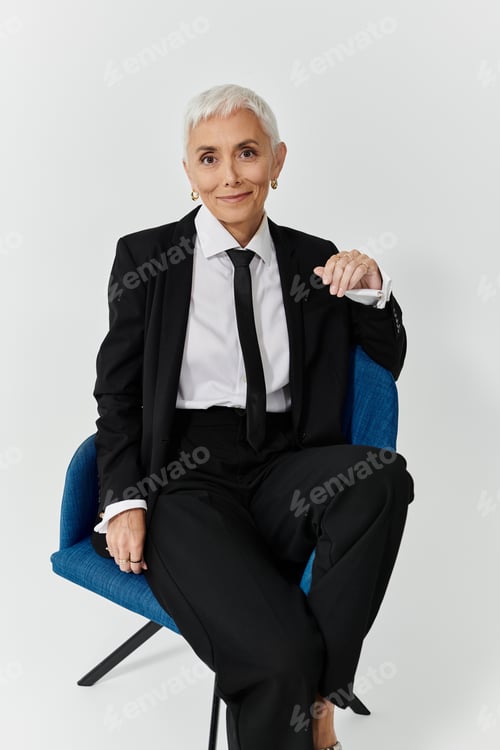 Preview: Elegant Woman in Stylish Suit Posed Comfortably in Modern Chair