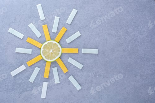 Preview: Slice of lemon in the center of a gum strip arrangement on marble background