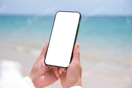 Preview: Mockup image of a woman holding mobile phone with blank desktop screen by the sea