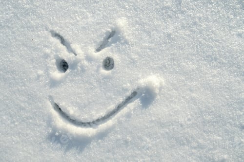 Preview: Face of an insidious, angry, smiley, painted on the snow on a sunny winter day. Top view.