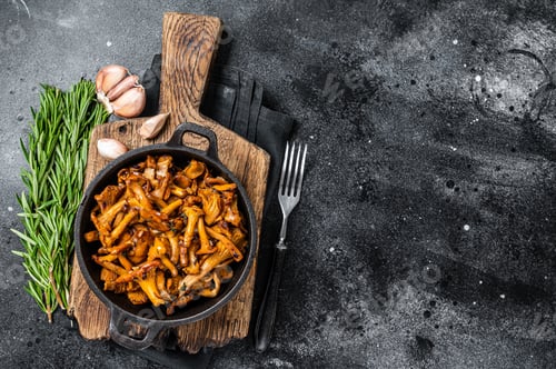 Preview: French roasted chanterelle mushrooms with onions and thyme in a pan. Black background