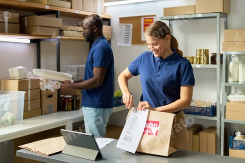 Preview: Young Caucasian Woman Packing Order While Black Man Organizing Inventory