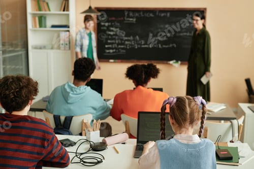 Preview: Group of children using computers at desks in school classroom