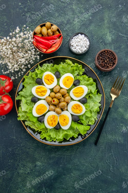 Preview: top view boiled sliced eggs with green salad and olives on dark blue background dish vegetable food