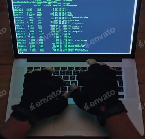 Preview: Your network has been breached. Shot of an unrecognisable hacker using a laptop in the dark.