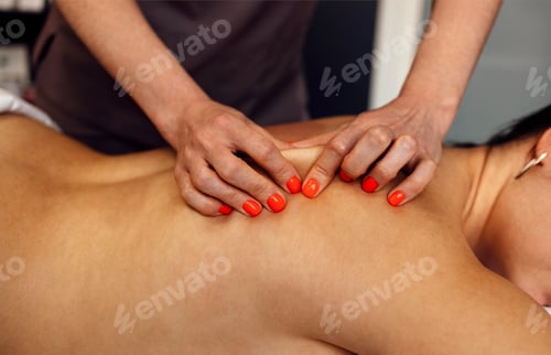 Preview: Happy young caucasian girl getting back massage in spa salon