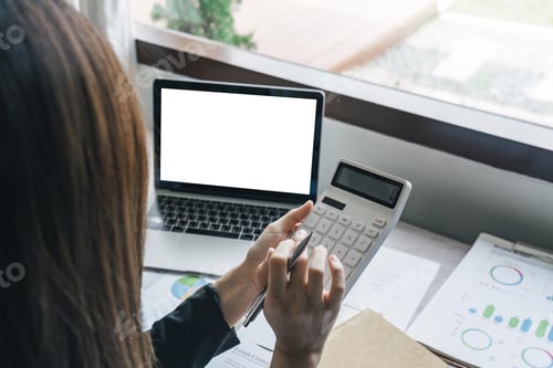 Preview: Bookkeeper using a calculator to calculate numbers on a company's financial documents, he is