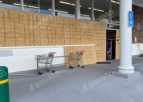 Preview: Store boarded up windows with sheets of plywood with grocery carts outside