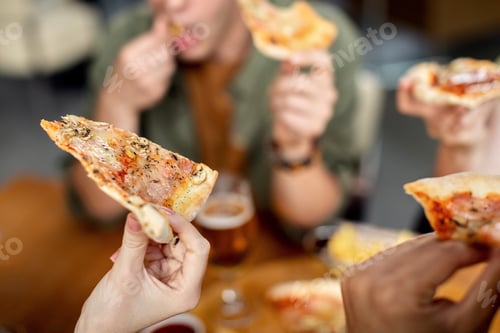 Preview: Close-up of woman eating pizza with friends.