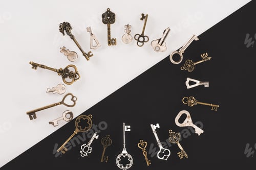 Preview: top view of different vintage keys circle frame over black and white background