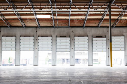 Preview: Wide angle interior view of largeempty warehouse and loading dock doors