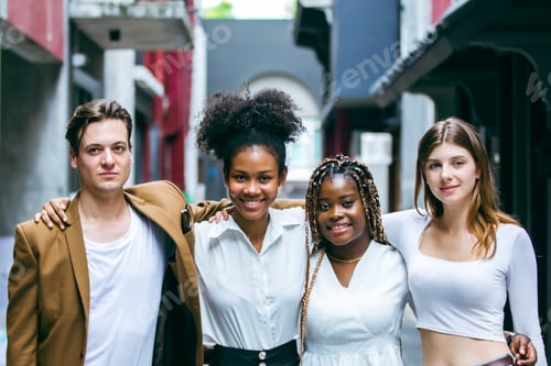 Preview: creative marketing team of young diverse professionals standing together outdoors