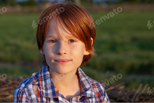 Preview: A large portrait of a red-haired boy with freckles in nature in the rays of the setting sun