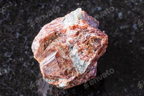 Preview: sample of raw eudialyte rock on black granite