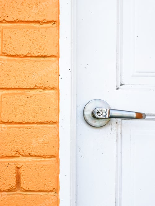 Preview: Image of dirty white wooden door with knob and yellow bricks wall.