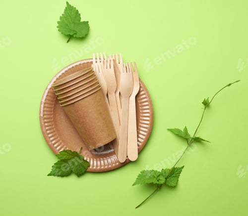 Preview: Disposable paper utensils from brown craft paper and recycled materials on a green background